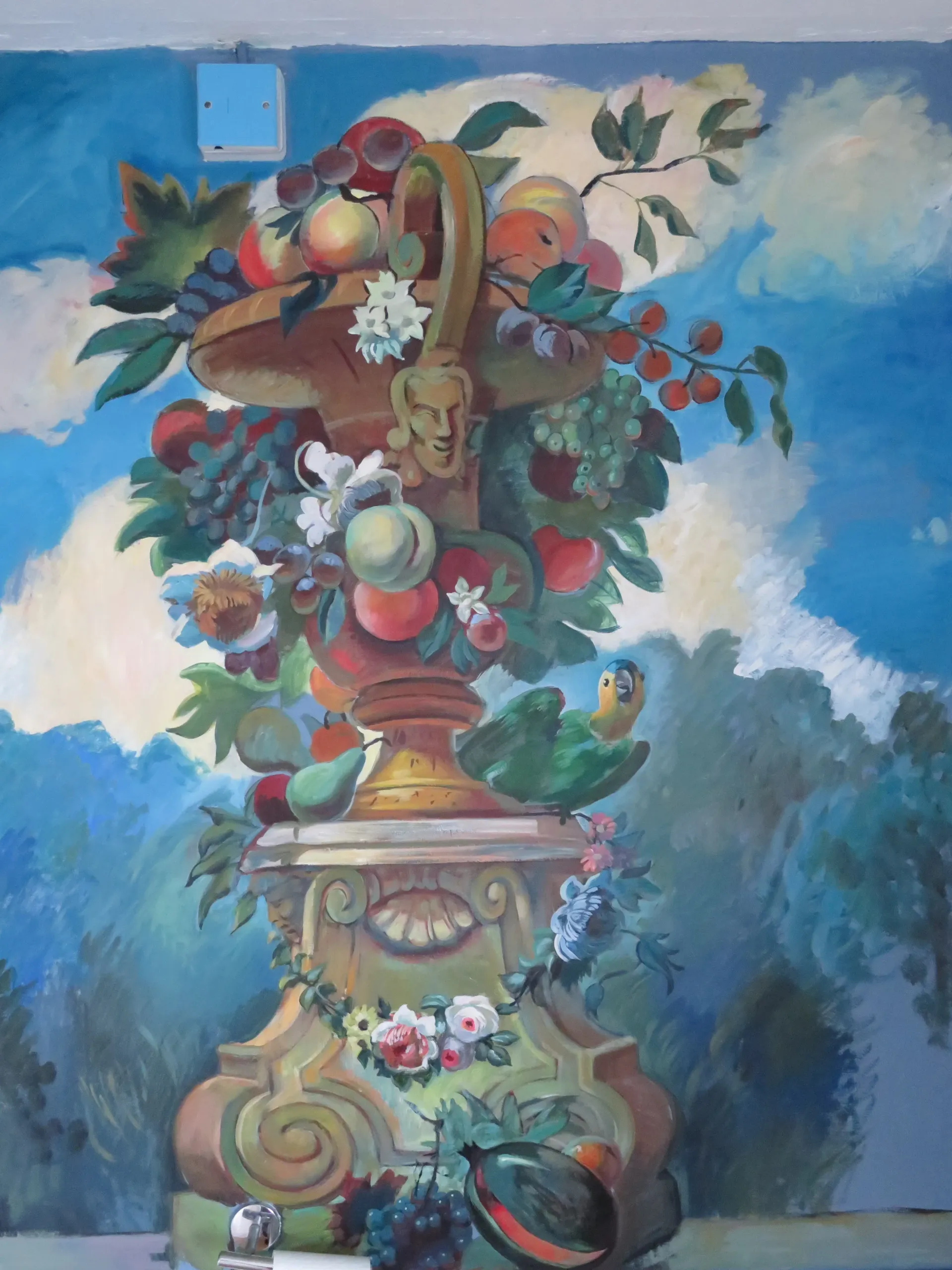 Colourful hand-painted garden mural with a classical urn, fruit, flowers, and a parrot